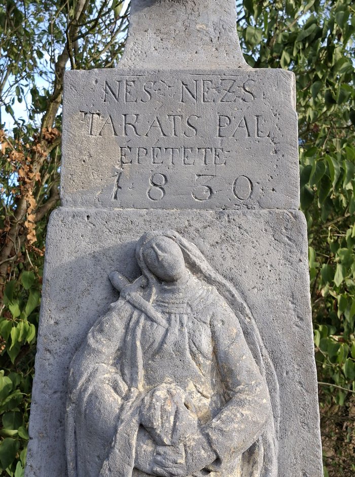 A kereszt talapzatának felirata közelről: NES NEZS TAKATS PAL EPETETE 1830, alatta Szűz Mária domborműve