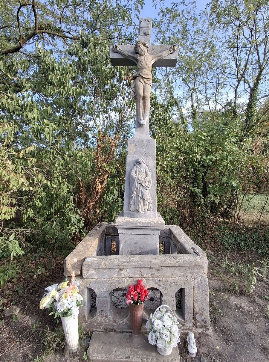 A lukafai Takáts-kereszt ma: kőfeszület korpusszal, a talapzaton a fájdalmas Szűz Mária domborműve és az 1830-as felirat, alul kőkorlát, előtte virágok